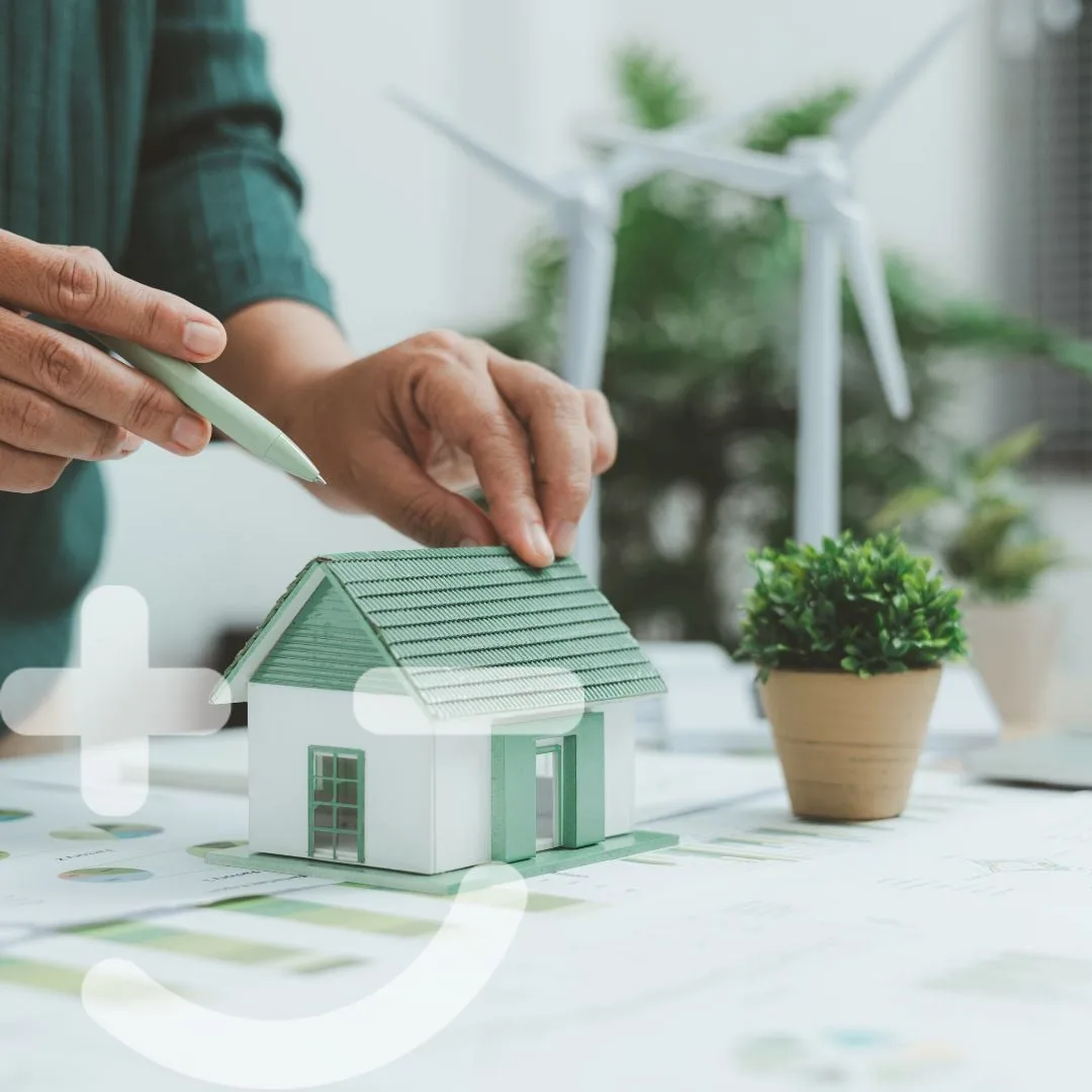 Handen zetten een modelwoning op renovatieplannen, met het Setle-logo erover